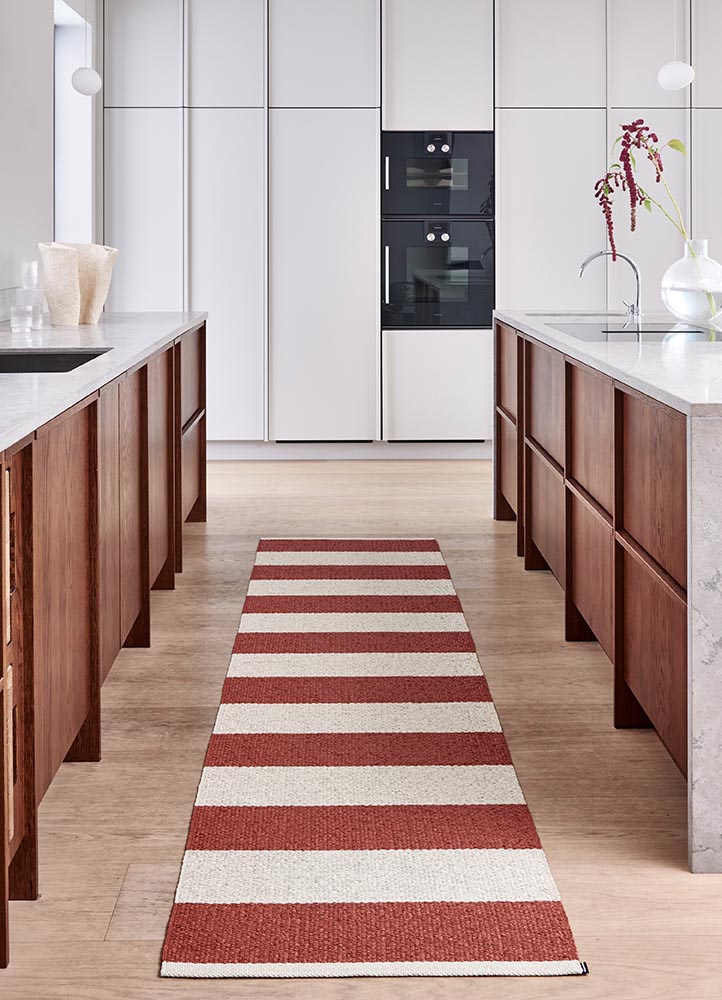 a red and white striped rug from Pappelina in a kitchen addorning the floor in give life to the space